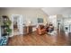 Open-concept living room with hardwood floors, leather furniture, and ample natural light at 2190 Coyote Creek Dr, Fort Lupton, CO 80621