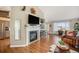 Bright living room with a cozy fireplace, built-in shelves, and access to the outdoor patio at 2190 Coyote Creek Dr, Fort Lupton, CO 80621