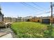 Fenced backyard with lush lawn, gravel area, and garden beds at 475 S Eliot St, Denver, CO 80219