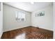 Bright bedroom featuring hardwood floors, fresh paint, and natural light from two windows at 475 S Eliot St, Denver, CO 80219