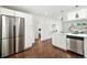 Open concept kitchen with stainless steel appliances, island, and hardwood floors at 475 S Eliot St, Denver, CO 80219