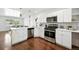Bright kitchen features stainless steel appliances, white cabinets, and island at 475 S Eliot St, Denver, CO 80219