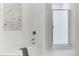 Clean bathroom design with a bathtub, glass shower door and tiled accent wall at 1440 Little Raven St # 107, Denver, CO 80202