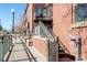 Brick condo exterior shows balcony, metal staircase, gray trim, and street lamp at 1440 Little Raven St # 107, Denver, CO 80202