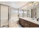 Bright bathroom featuring double sinks, separate shower, soaking tub, and modern fixtures at 9113 E 36Th Ave, Denver, CO 80238