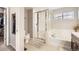 Bright bathroom featuring shower, soaking tub, and modern fixtures at 9113 E 36Th Ave, Denver, CO 80238