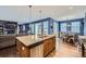 Open kitchen features a central island, stainless steel appliances, and seamless flow into the dining area at 9113 E 36Th Ave, Denver, CO 80238
