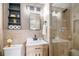 Modern bathroom featuring a stylish vanity, glass-enclosed shower, and a decorative wood-slat wall at 6576 S Lincoln St, Centennial, CO 80121