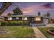 Charming single-story home featuring a brick facade, a well-manicured lawn, and a cozy front bench at 6576 S Lincoln St, Centennial, CO 80121