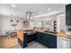 Modern kitchen with custom wood counters, navy cabinets, stainless steel appliances, and open concept layout at 6576 S Lincoln St, Centennial, CO 80121