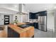 Stylish kitchen with wood countertops, stainless steel appliances, dark blue cabinets, and modern fixtures at 6576 S Lincoln St, Centennial, CO 80121