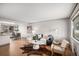 Bright and airy living room featuring neutral decor, hardwood floors, and a large window overlooking the street at 6576 S Lincoln St, Centennial, CO 80121