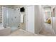 Bathroom with glass shower, soaking tub, and doorway leading into bedroom at 6702 S Winnipeg Cir # 101, Aurora, CO 80016