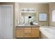 Well-lit bathroom vanity, large mirror, and bath featuring a glass shower at 6702 S Winnipeg Cir # 101, Aurora, CO 80016