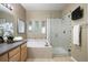 Bright bathroom featuring a soaking tub, glass-enclosed shower, and vanity at 6702 S Winnipeg Cir # 101, Aurora, CO 80016