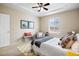 Light-filled bedroom with carpet, tray ceiling, and chair near window at 6702 S Winnipeg Cir # 101, Aurora, CO 80016