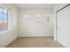 Neutral bedroom featuring three windows, carpet floors and a closet at 6702 S Winnipeg Cir # 101, Aurora, CO 80016