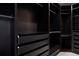 Spacious walk-in closet with dark wood shelving, drawers, and hanging rods at 6702 S Winnipeg Cir # 101, Aurora, CO 80016