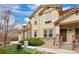 Exterior side view of townhome featuring stone accents and manicured landscaping at 6702 S Winnipeg Cir # 101, Aurora, CO 80016