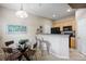 Open-concept kitchen with breakfast bar, glass dining table, and modern appliances at 6702 S Winnipeg Cir # 101, Aurora, CO 80016