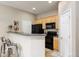Clean kitchen with black appliances and counter-height bar at 6702 S Winnipeg Cir # 101, Aurora, CO 80016
