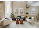 Bright living room with two chairs, featuring a staircase and ample natural light from windows at 6702 S Winnipeg Cir # 101, Aurora, CO 80016