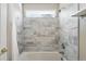 Bright tub-shower with modern gray tile, window and chrome shower head at 9265 Buttonhill Ct, Highlands Ranch, CO 80130
