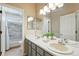 Bright bathroom with double sink vanity, and a shower-tub featuring modern gray tile at 9265 Buttonhill Ct, Highlands Ranch, CO 80130
