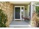 Welcoming front porch with stone accents, decorative seating, and a charming entrance door at 9265 Buttonhill Ct, Highlands Ranch, CO 80130