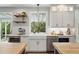 Bright kitchen with farmhouse sink, stainless steel appliances, open shelving, and white cabinets at 9265 Buttonhill Ct, Highlands Ranch, CO 80130