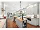 Spacious kitchen featuring double islands, stainless appliances, white cabinets, and hardwood floors at 9265 Buttonhill Ct, Highlands Ranch, CO 80130