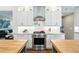 Kitchen with stainless steel range and hood, white cabinets, and granite countertops at 9265 Buttonhill Ct, Highlands Ranch, CO 80130