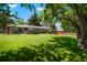 Spacious backyard with lush green lawn and mature trees providing shade, framed by a wood fence at 2964 S Akron St, Denver, CO 80231