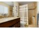 Bathroom with a wood vanity and granite countertop and a shower with patterned shower curtain at 2964 S Akron St, Denver, CO 80231