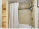 Bright bathroom featuring a tiled shower with a built-in niche and a neutral colored shower curtain at 2964 S Akron St, Denver, CO 80231