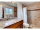Bathroom featuring granite countertop, wood cabinetry, shower, tub and tile flooring at 2964 S Akron St, Denver, CO 80231