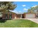 Charming brick home with mature trees, a well-maintained lawn, and an attached two-car garage at 2964 S Akron St, Denver, CO 80231