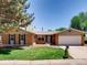 Charming single-story brick home featuring a well-maintained lawn, mature trees, and attached two-car garage at 2964 S Akron St, Denver, CO 80231