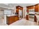 Well-lit kitchen with stainless steel appliances, granite countertops, tile flooring, and dark wood cabinetry at 2964 S Akron St, Denver, CO 80231