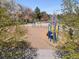 Colorful community playground with swings, slide, and padded ground with surrounding mature landscaping and trees at 2964 S Akron St, Denver, CO 80231