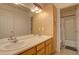 Spacious bathroom with double sinks, warm lighting and light-colored wood cabinets at 2283 S Bannock St, Denver, CO 80223
