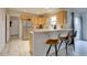 Well-lit kitchen with light wood cabinets, breakfast bar, and stainless steel appliances at 2283 S Bannock St, Denver, CO 80223