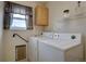 Bright laundry room features a modern washer and dryer with a cabinet above at 2283 S Bannock St, Denver, CO 80223