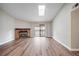 Bright living room with hardwood floors, skylight, brick fireplace, and sliding door to balcony at 18133 E Kentucky Ave # 203, Aurora, CO 80017