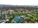 Aerial view showcases the community's golf course, tennis courts, swimming pool, and residential area surrounded by lush greenery at 18 Club Ln, Littleton, CO 80123
