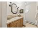 Clean and classic powder room featuring a wooden vanity and a lovely mirror at 18 Club Ln, Littleton, CO 80123