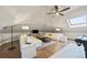 Bright bonus room with skylights, plush couches, and modern entertainment setup at 18 Club Ln, Littleton, CO 80123
