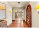 Elegant hallway featuring hardwood floors, archways, and decorative wood door leading to the brightly lit Gathering room at 18 Club Ln, Littleton, CO 80123