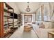 Charming living room with TV, shelves, white couches, a wicker table, and natural lighting at 18 Club Ln, Littleton, CO 80123