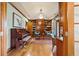 Home office featuring a hardwood floor, custom built-in shelving, and a grand piano at 18 Club Ln, Littleton, CO 80123